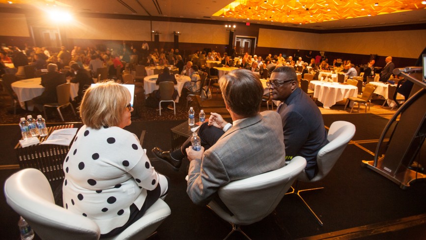 three people sitting on a stage at Partnership Day