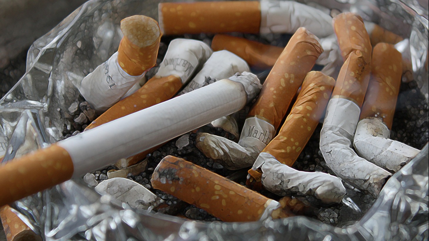 A bunch of cigarette butts in an ashtray 