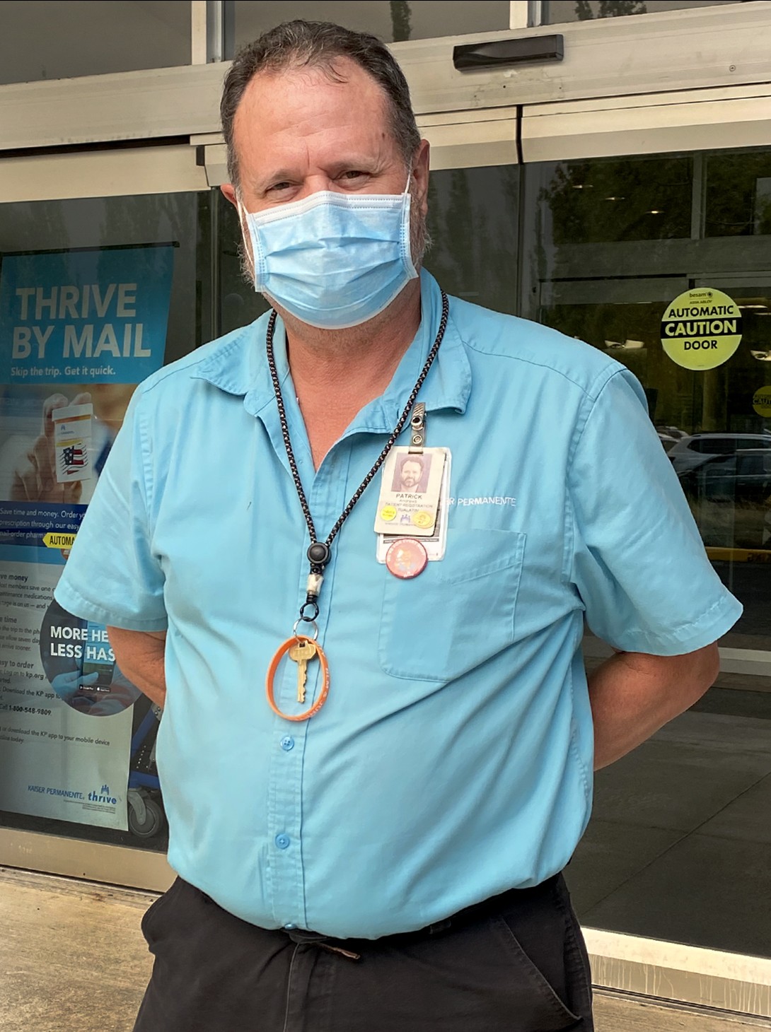 Portrait of a man, wearing a teal shirt and a mask