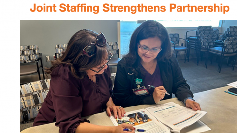 Two team members review documents together