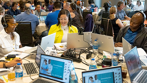 group of people sitting working together on computers