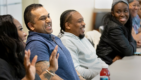 men and women sitting at table laughing