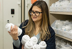 woman holding bottles and viewing one of them