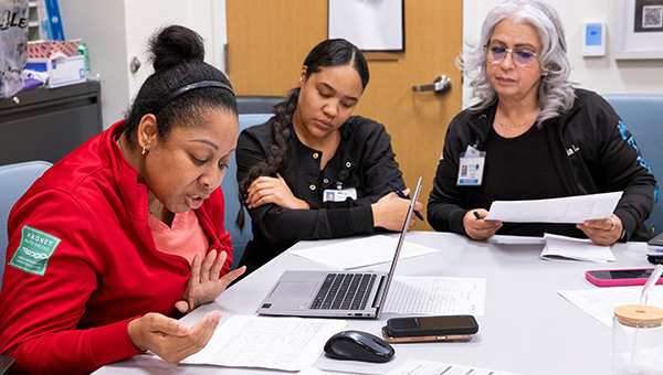 3 women at a table reviewing materials
