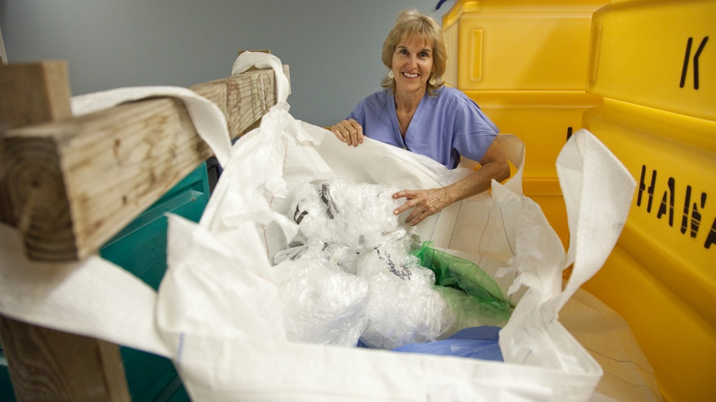 Nurse at huge yellow recycling bin 