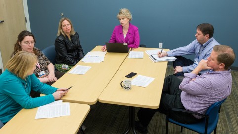 group of people sitting around a conference table 