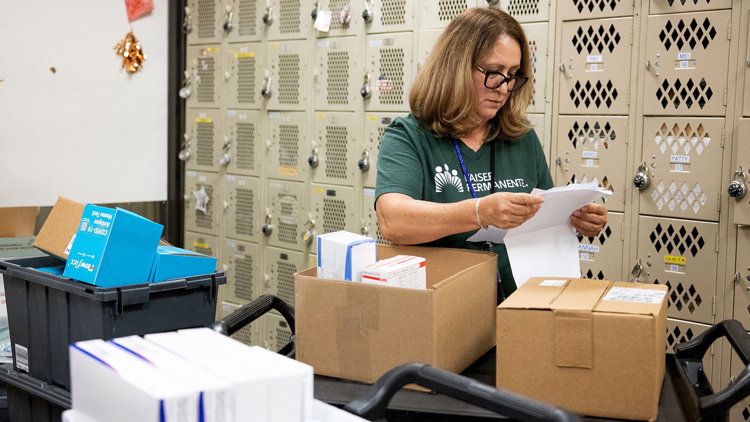woman in green shirt looking at a paper
